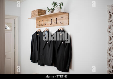 Blazers hanging on wall at home Stock Photo
