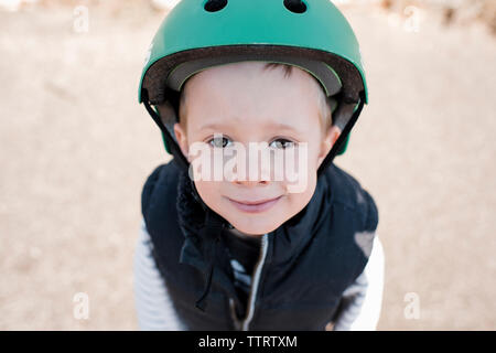 High angle portrait of boy wearing helmet standing at park Stock Photo