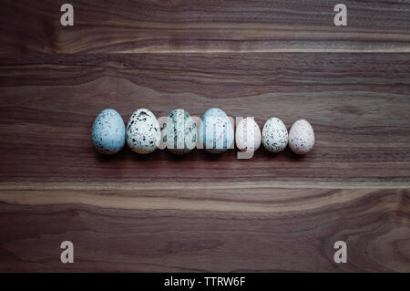 Overhead view of colorful easter eggs arranged on wooden table Stock Photo