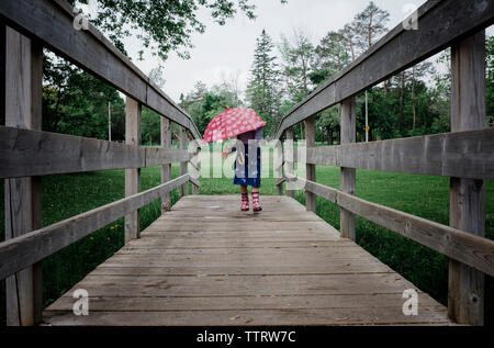 Girl walking with umbrella on rainy day Stock Photo - Alamy
