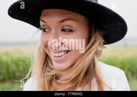 Close-up of happy woman wearing hat while standing against plants Stock Photo