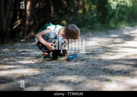 Boy looking on field through binoculars in forest Stock Photo