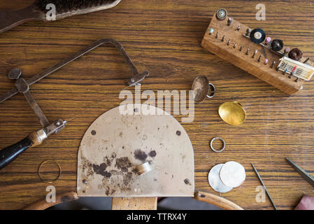 Overhead view of work tools with ring on wooden workbench in workshop Stock Photo