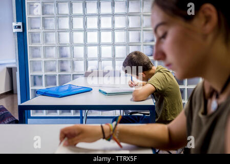 Students studying while sitting in classroom Stock Photo