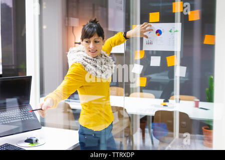 Businesswoman explaining chart note to colleagues in creative office Stock Photo