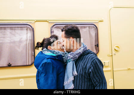 Couple standing while kissing outdoors Stock Photo