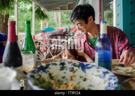 Father and son having lunch at dining table on porch Stock Photo