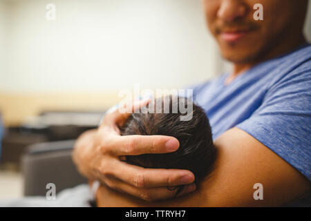 a proud father gently holds his daughter in his arms cradling her head Stock Photo