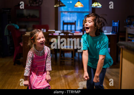 Siblings laughing and singing together at home Stock Photo