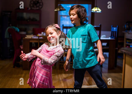 Portrait of happy siblings dancing together at home Stock Photo