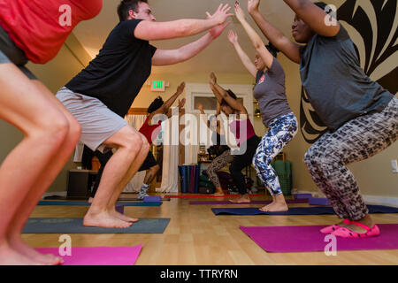 A small group of students practice yoga poses together Stock Photo