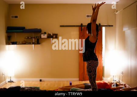 a yoga instructor guides students through peaceful meditation Stock Photo