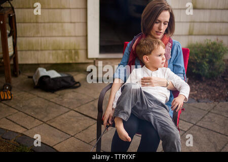 a mother sits outside with her small child in her lap Stock Photo