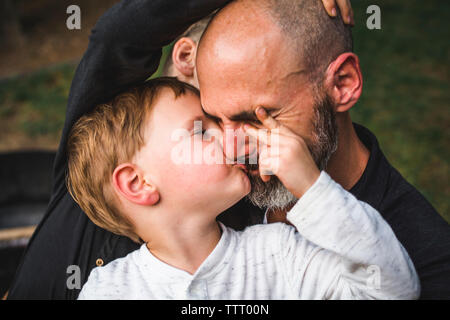 Portrait of A little boy kissing his father