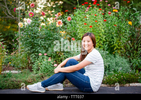 Portrait of a teenage girl sitting in a garden Stock Photo