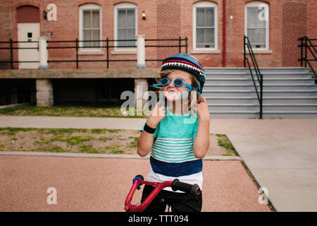 Happy girl wearing goggles while standing with bicycle Stock Photo