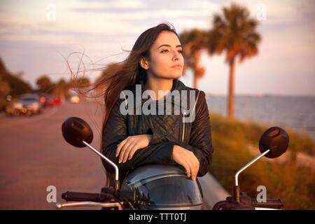 Close-up of young woman riding motorcycle on street Stock Photo