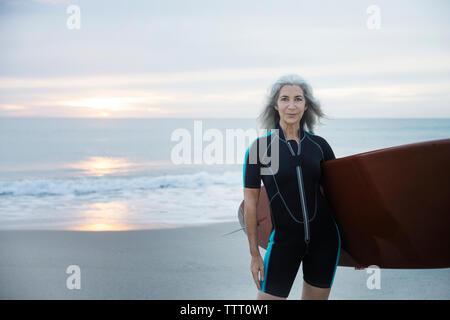 Portrait of confident female surfer carrying surfboard at Delray Beach Stock Photo