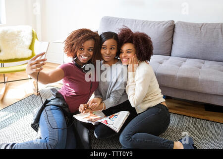 Happy female friends taking selfie at home Stock Photo