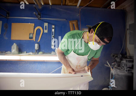 worker making surfboard in workshop Stock Photo