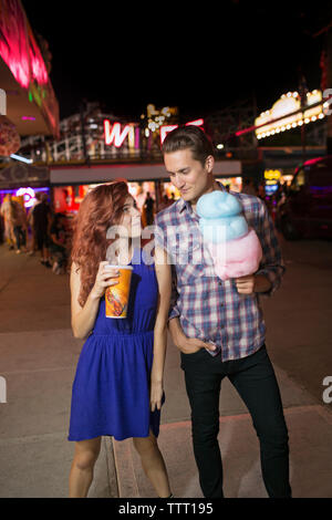 Young couple standing side by side at amusement park Stock Photo