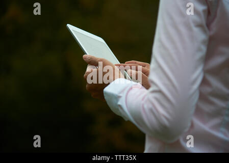 Midsection of businesswoman using tablet computer at park Stock Photo