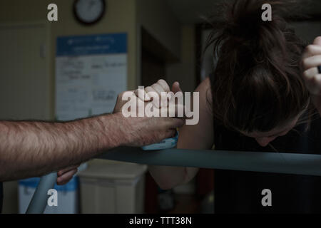 Cropped hand of man comforting painful pregnant woman in hospital ward Stock Photo