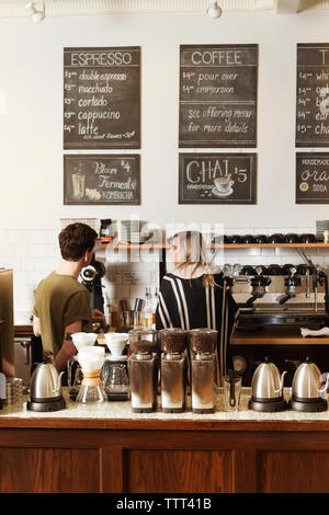 Woman Holding Coffee Cup With Owners In Cafe Stock Photo Alamy