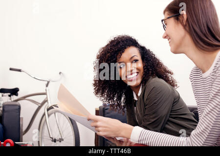 Happy businesswomen discussing over documents at office Stock Photo