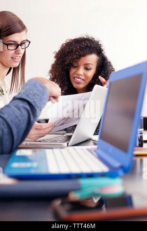Cropped image of man explaining documents to businesswomen at office Stock Photo