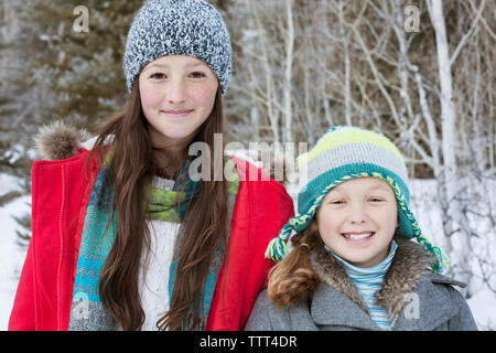 Portrait of happy sisters in warm clothing Stock Photo