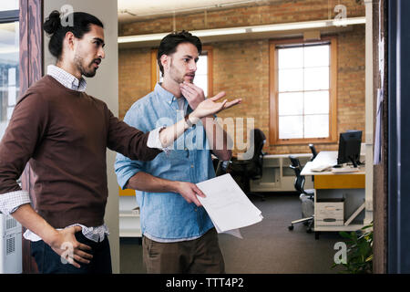 business people discussing while standing in office Stock Photo