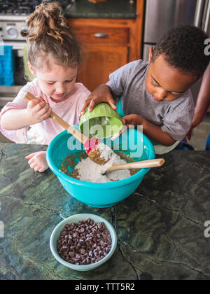 Boy and girl working together to make cookies Stock Photo