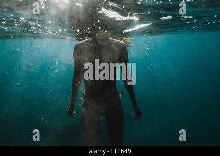 Dramatic partial underwater view of a woman in a bikini Stock Photo