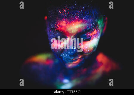 Conceptual shot of light and shine fluorescent colors young girl's face Stock Photo