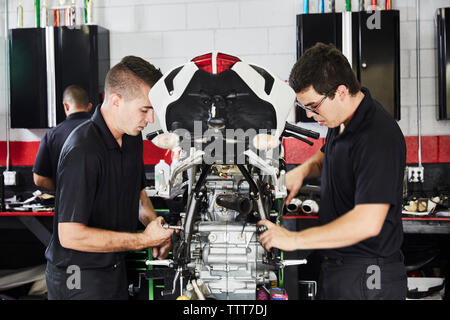 workers examining motorbike in factory Stock Photo