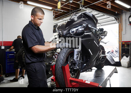 Colleagues making motorcycle in factory Stock Photo