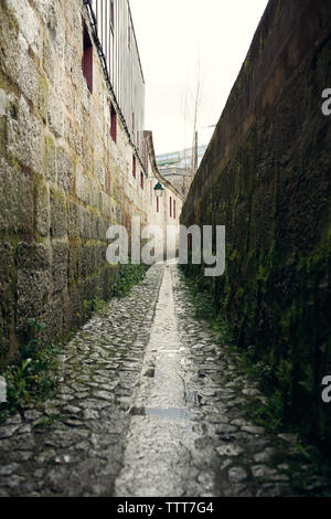 Narrow pathway amidst walls Stock Photo