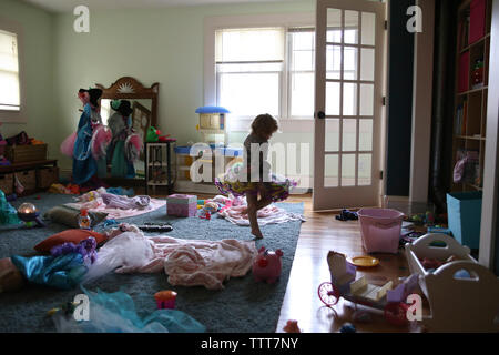 Girl dancing in messy room at home Stock Photo