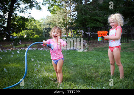 Happy sisters playing in backyard Stock Photo