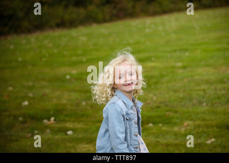 portrait of young girl with blonde hair smiling outside in the fall Stock Photo