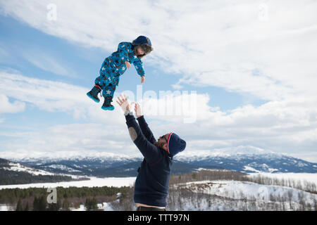 Father son playing in snowy mountain in winter wonderland Stock Photo