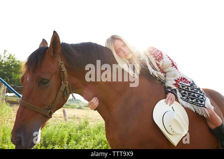 Low angle view of woman sleeping on horse in farm Stock Photo