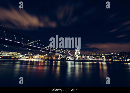 View of St. Paul's Cathedral amidst illuminated city by Thames River against sky at night Stock Photo