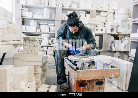 Craftsman using pottery wheel while working in workshop Stock Photo