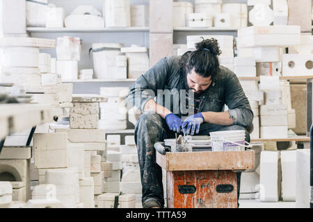 Craftsman using pottery wheel while working in art studio Stock Photo