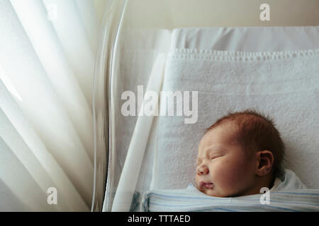 Overhead view of newborn baby girl sleeping in crib at hospital Stock Photo