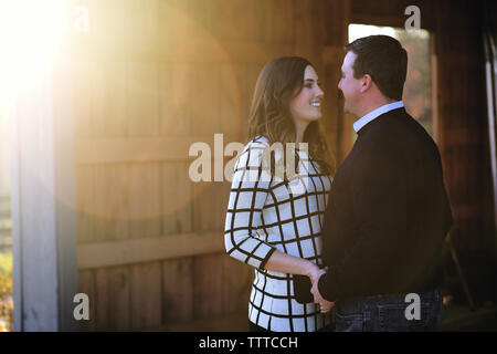 Husband and wife looking at each other while standing outdoors Stock Photo