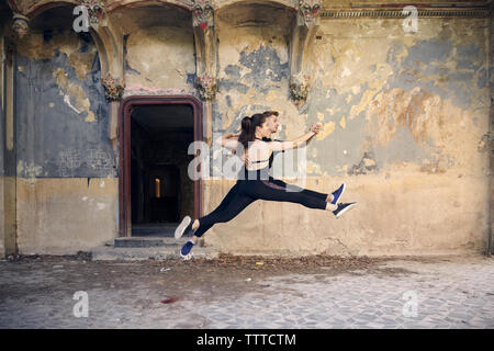 Ballet dancers leaping while dancing together in old building Stock Photo