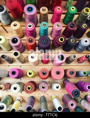 High angle view of colorful spools in wooden table Stock Photo